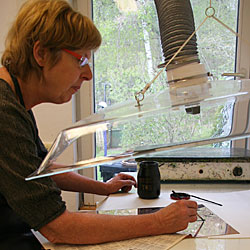 Catharina målar på kopparplåten.