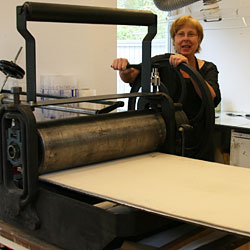Catharina justerar trycket i tryckpressen.